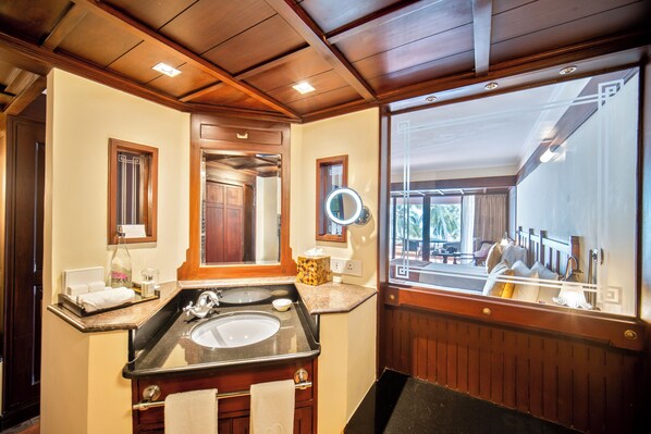 A bathroom with a large mirror, wooden ceiling, and a view of the outdoors. - The Leela Kovalam, a Raviz Hotel (Neyyattinkara)