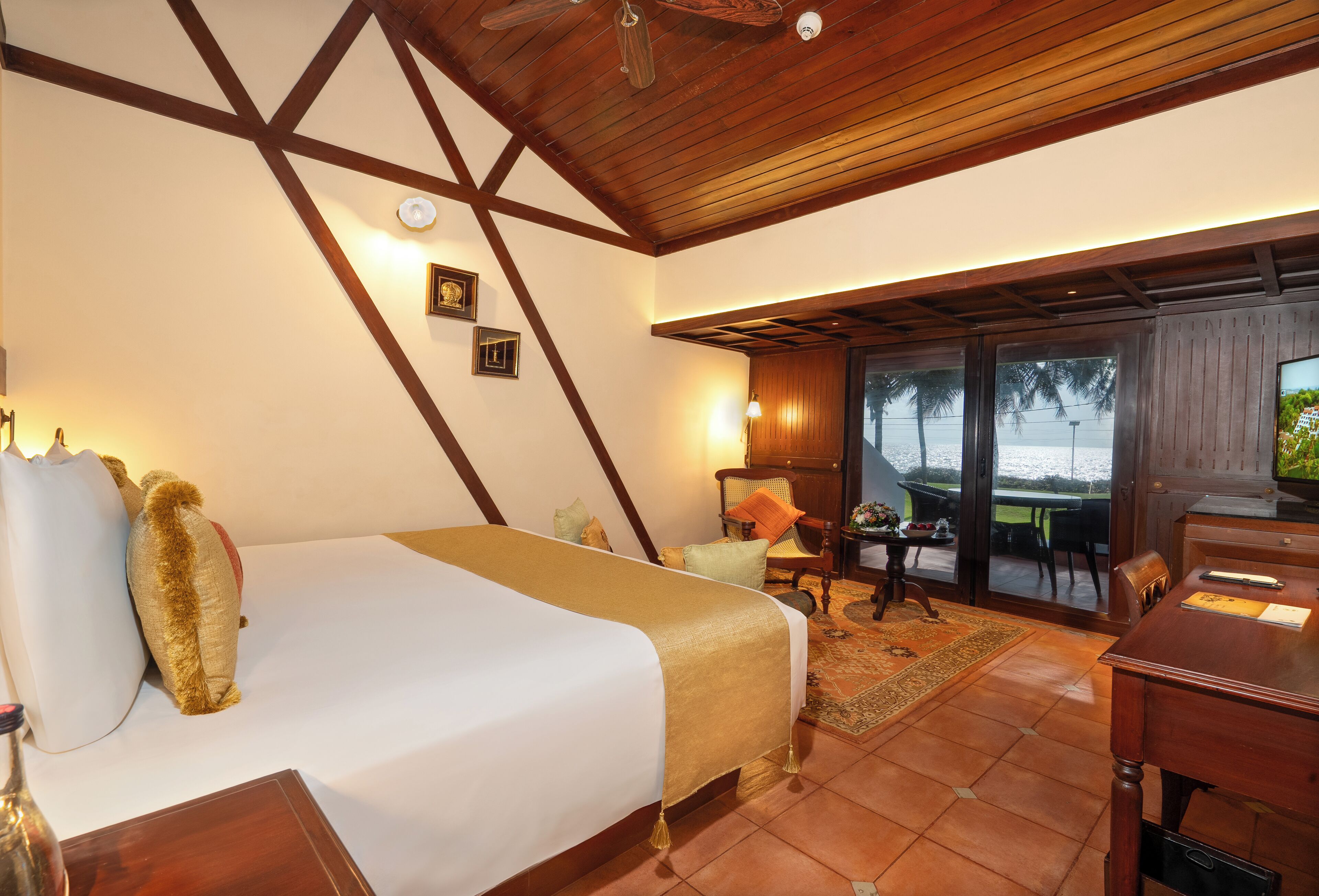 A hotel room with a bed, a desk, a chair, a table, and a view of the outdoors.