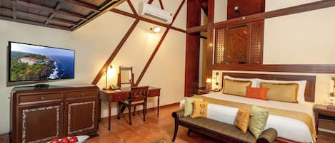 A hotel room with a bed, a desk, a television, and a dining area with a table set for two.
