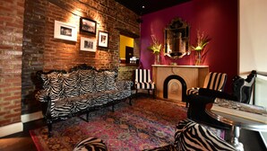 A room with a zebra-patterned sofa, a fireplace, and a mirror on the wall.