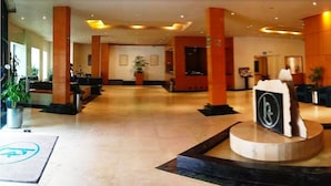 A spacious lobby with high ceilings, large pillars, and a central reception desk. - Hotel Sevilla (Mexico City)