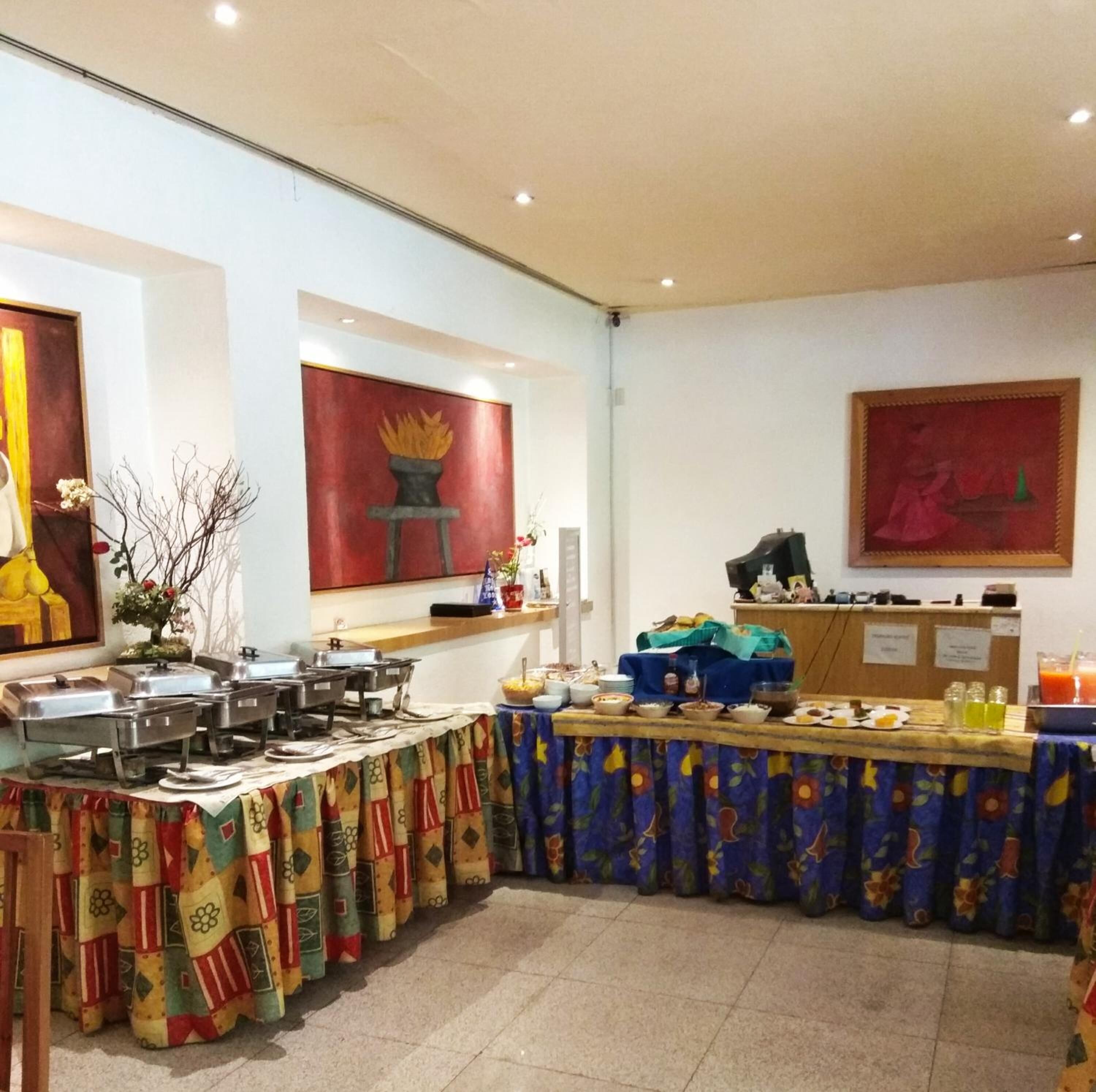 A buffet setup with various food items and a decorative curtain.