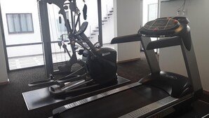 A gym with a treadmill and elliptical machine. - Bristol Hotel (Mexico City)
