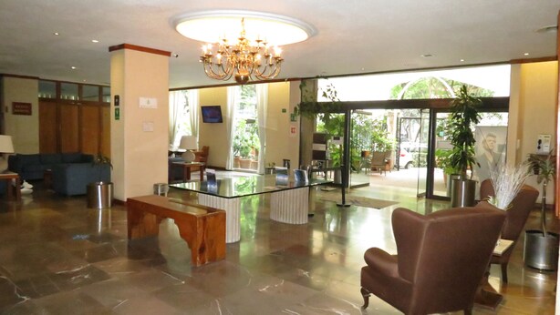 A spacious lobby with a glass coffee table, comfortable seating, and a chandelier. - Bristol Hotel (Mexico City)