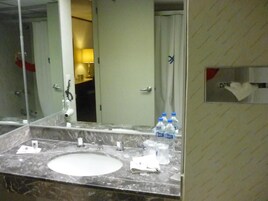 Un bagno con un lavabo in marmo, uno specchio e un porta asciugamani.