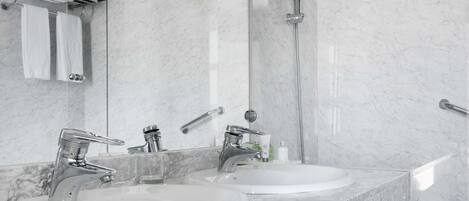 A modern bathroom with two sinks, a shower, and a glass-enclosed shower area.