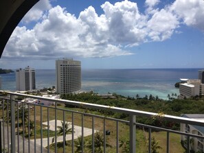 Overlooking the ocean, this hotel offers stunning views of a distant island amidst lush greenery.
