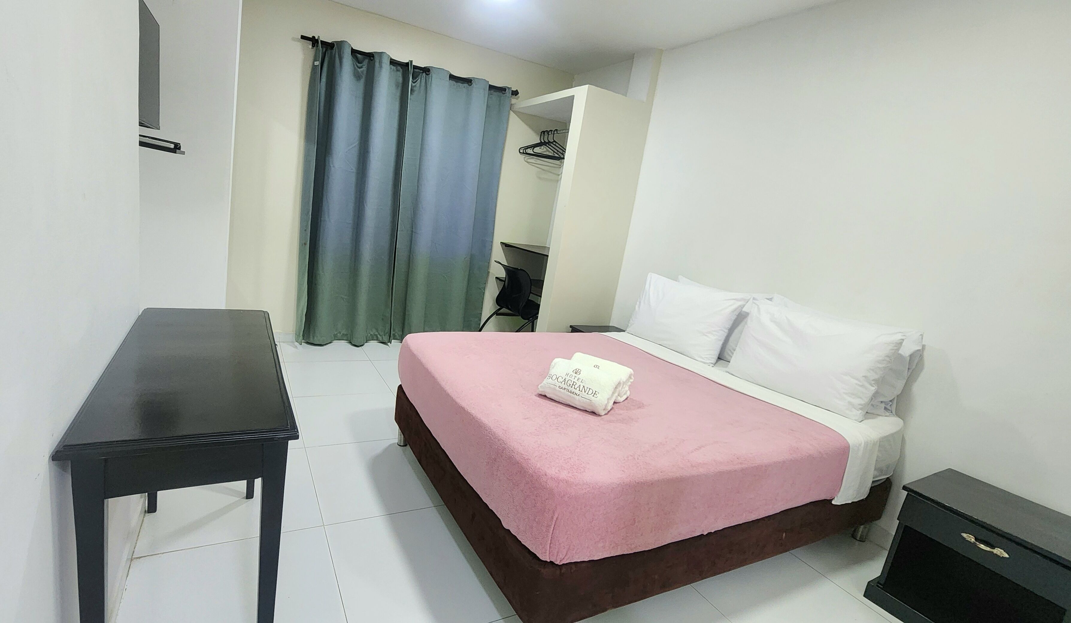Habitación de hotel con cama, escritorio y armario.