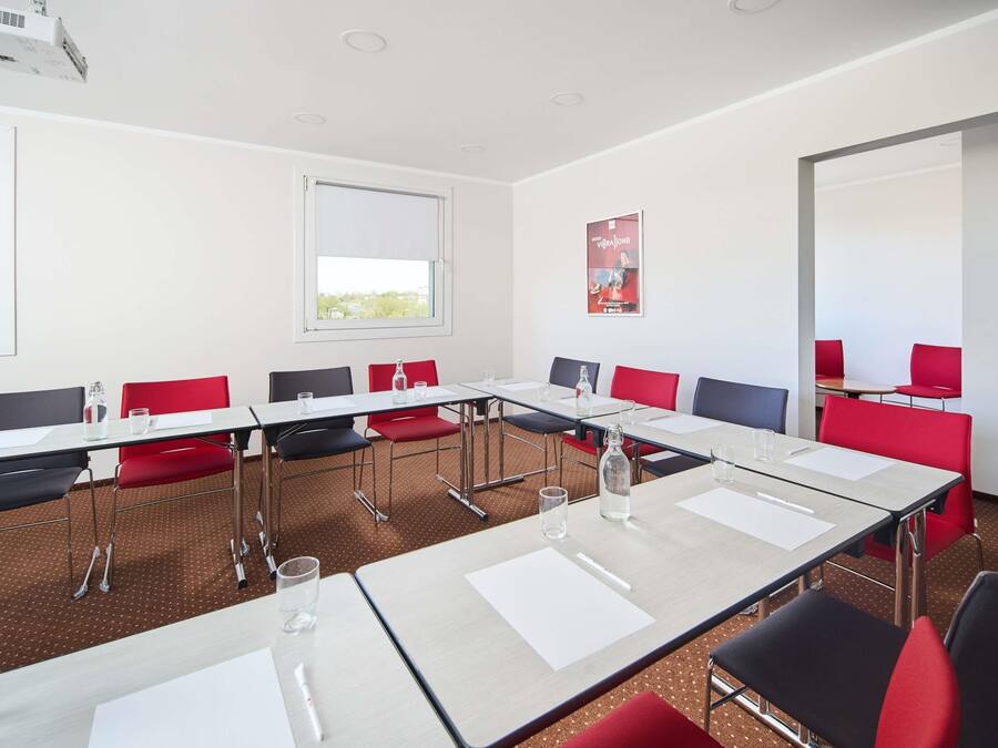 A conference room with tables, chairs, and a projector.