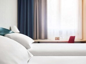 A hotel room with a bed, a desk with a laptop, and a window with curtains. - ibis Czestochowa (Czestochowa)