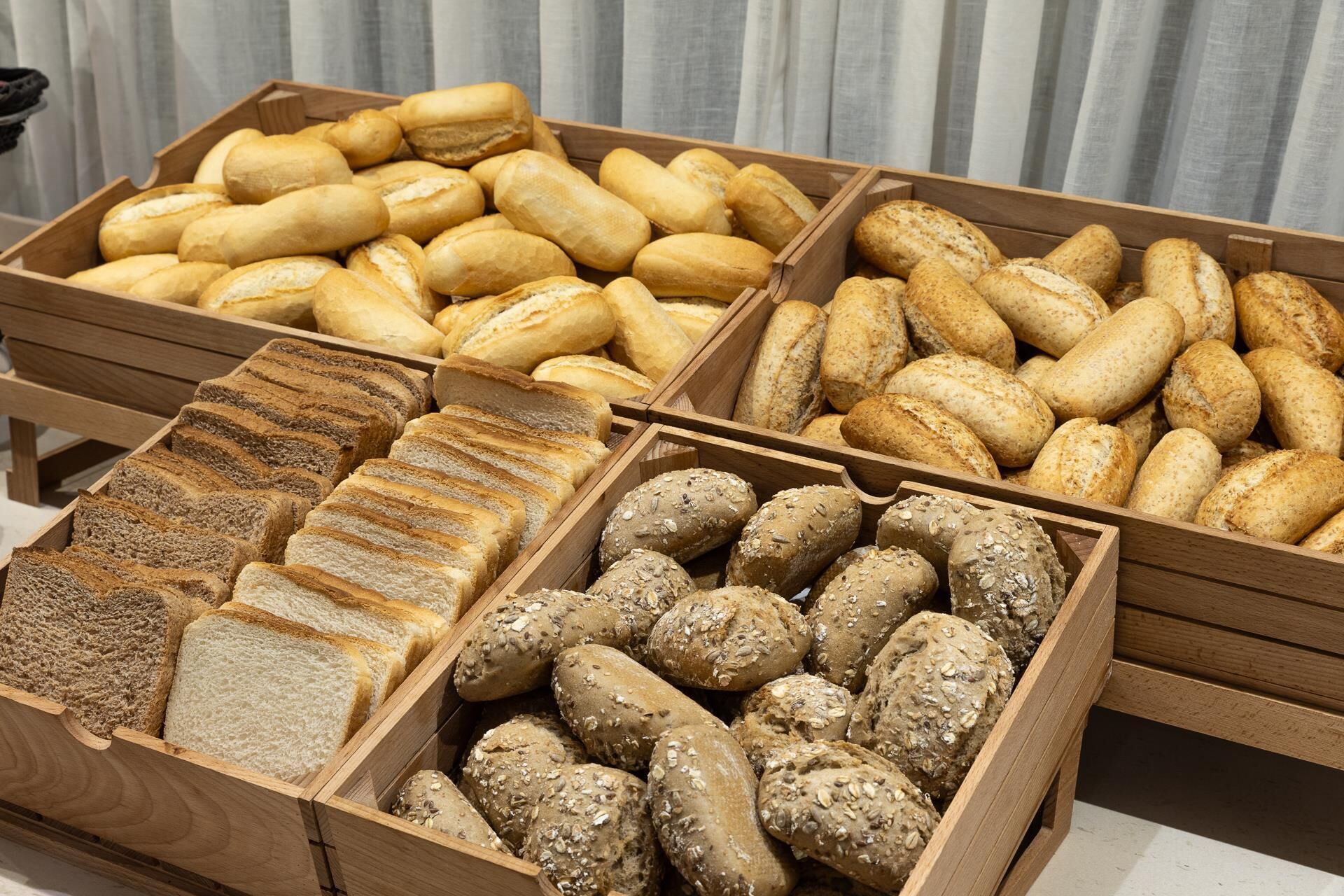 A variety of bread displayed in wooden crates.