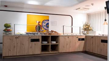 Una cocina moderna con armarios de madera, una exposición de frutas y un adorno de pared.