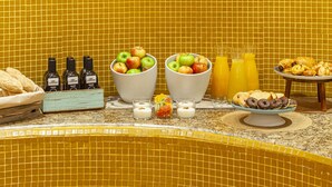 Ein Badezimmer mit gelb gefliesten Wänden, einer Hängelampe und verschiedenen Pflege- und Lebensmittelartikeln auf der Ablagefläche.