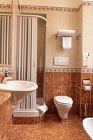 A bathroom with a sink, toilet, shower, and towel rack.
