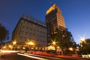 A multi-story hotel with a prominent corner building and a well-lit street in the foreground. - Hotel Clarendon (Québec City)