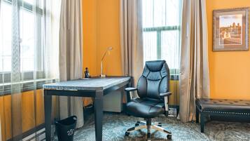 Une pièce comprenant un bureau, un fauteuil de bureau et un banc.
