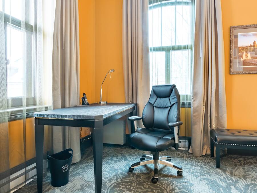 Une pièce comprenant un bureau, un fauteuil de bureau et un banc.