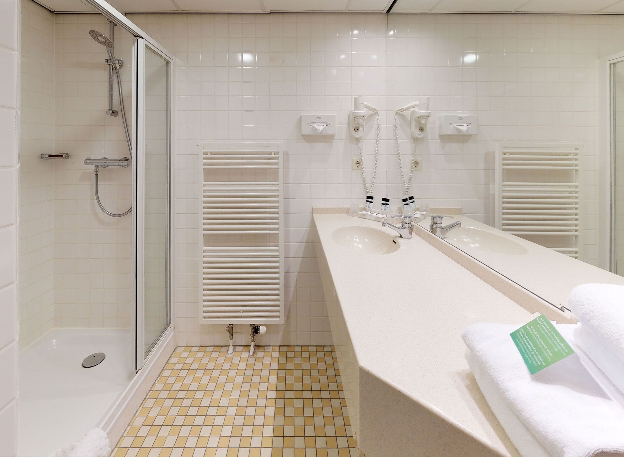 A modern bathroom with a shower, a large sink, and a toilet.