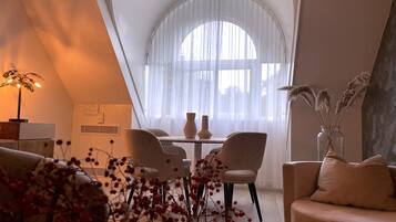 Een modern interieur met een eethoek, een bank en een decoratieve plantencompositie.