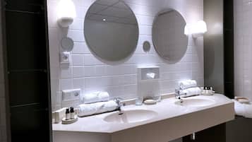 Un bagno moderno con due lavabi, ampi specchi e un portasciugamani.