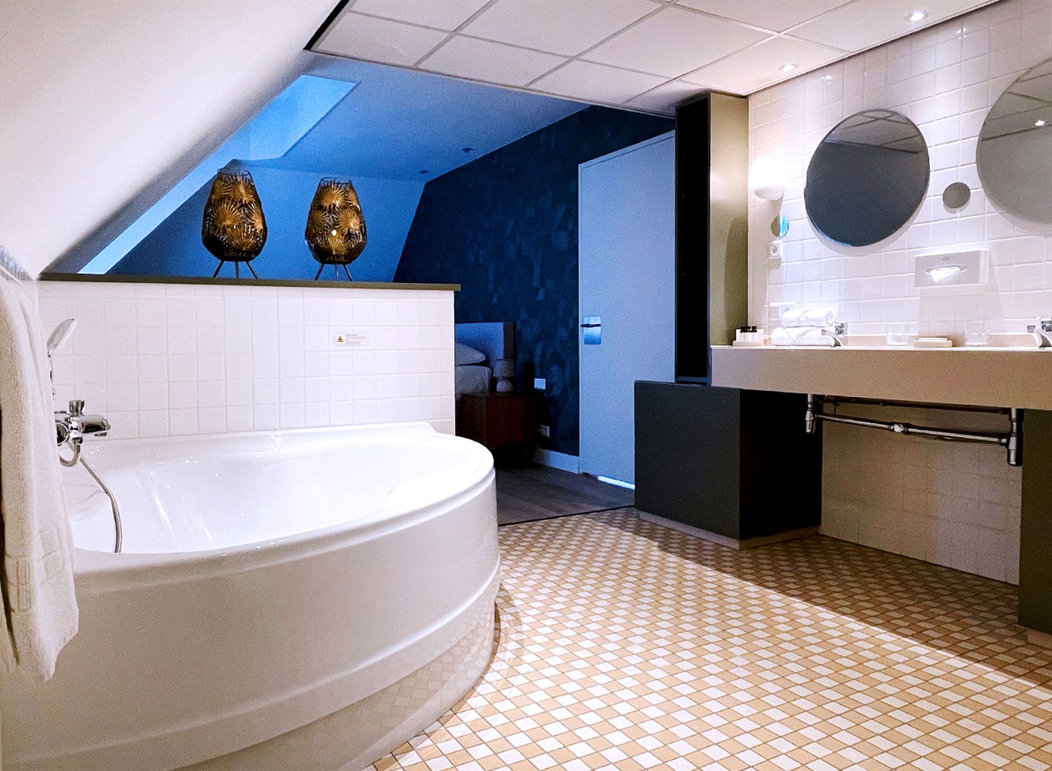 A modern bathroom with a large bathtub, a sink, and a mirror.
