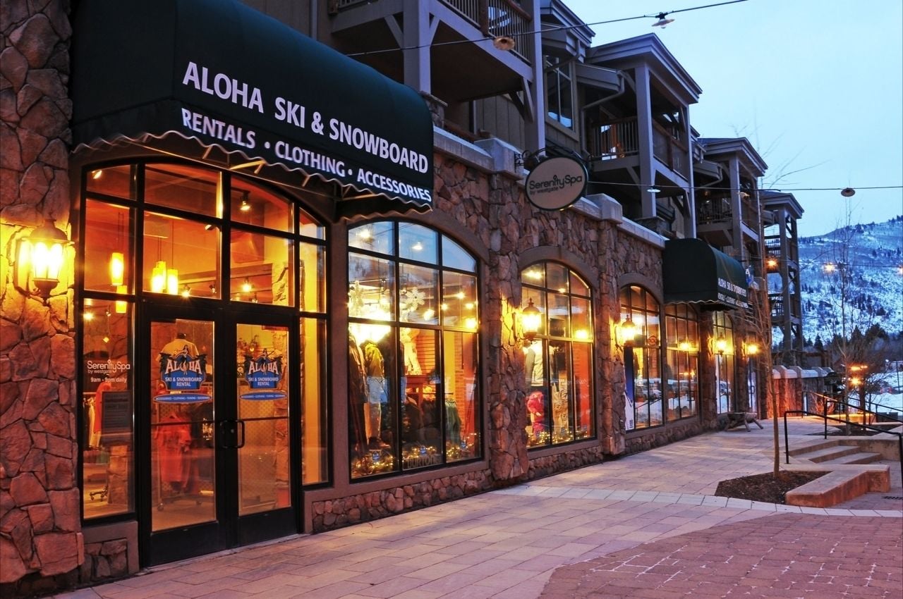 Un edificio con un letrero de alquiler de esquíes y tablas de snowboard, ropa y accesorios Aloha.