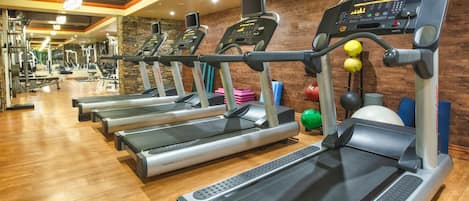 A gym with treadmills, exercise balls, and various fitness equipment.