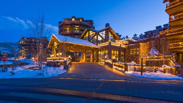 A lodge with a snow-covered entrance, wooden exterior, and multiple balconies.