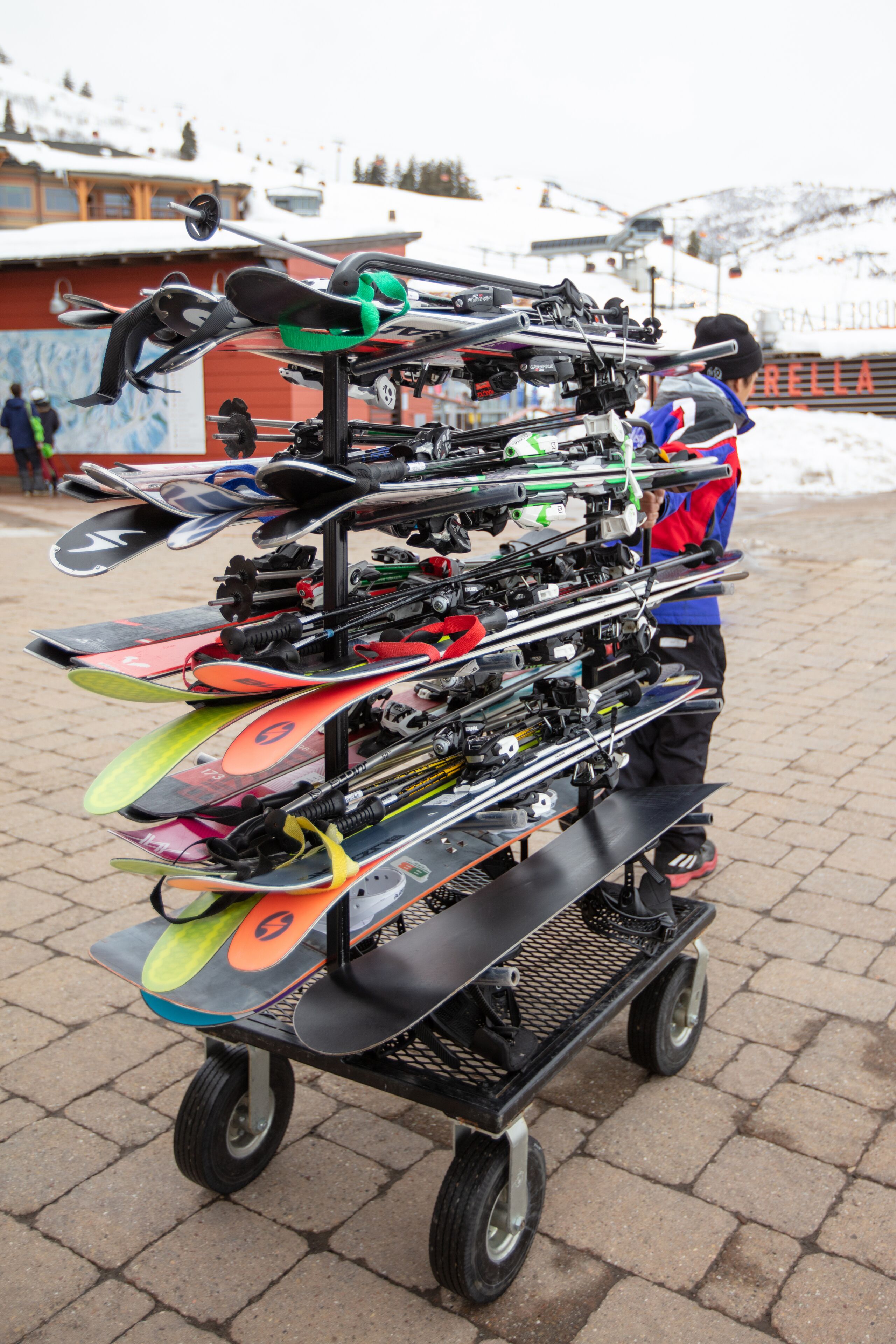 Un carrito con esquíes y tablas de snowboard en un entorno nevado al aire libre.