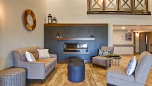 A modern living room with two sofas, a coffee table, and a round ottoman. - Canalta Hotel Brooks (Brooks)