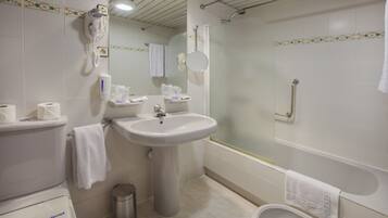 Une salle de bain avec des toilettes, un lavabo et une baignoire.