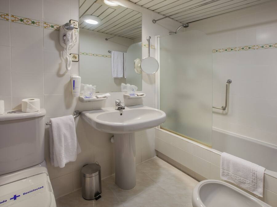 Une salle de bain avec des toilettes, un lavabo et une baignoire.