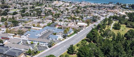 Vista aérea de una zona residencial con casas, una carretera principal y la costa al fondo.