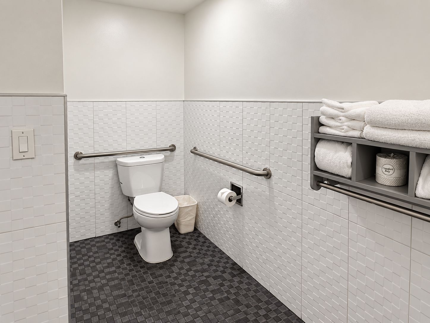 Een badkamer met toilet, handgrepen, een handdoekhouder en een prullenbak.