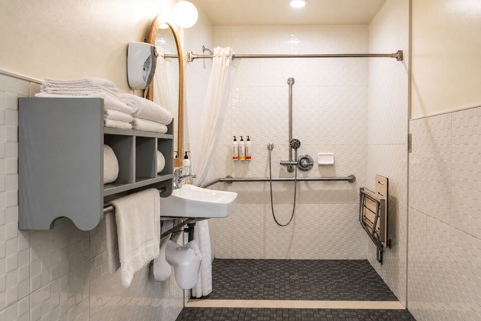 A modern bathroom with a shower, two sinks, a towel rack, and a mirror.