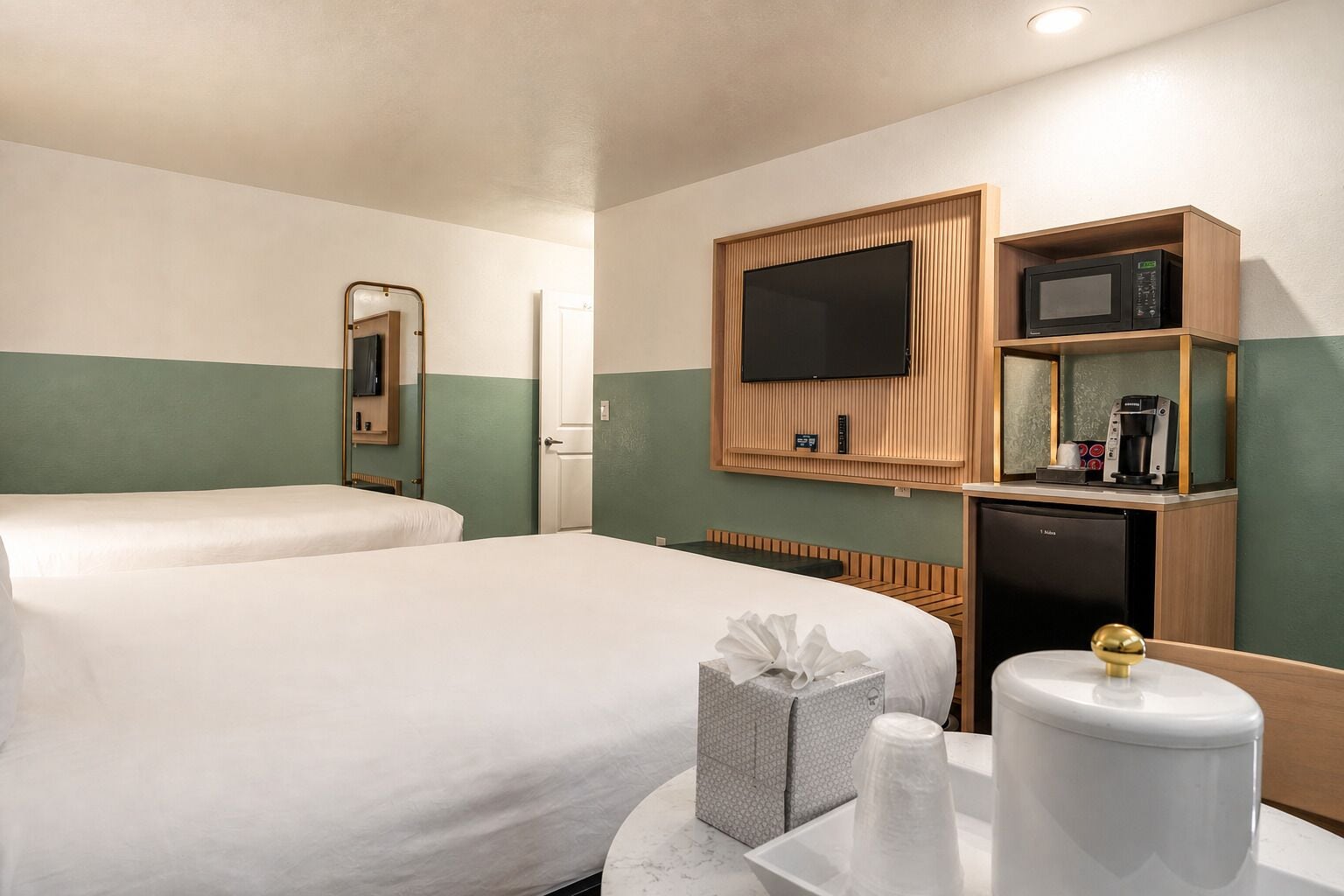 Une chambre d’hôtel avec deux lits, une télévision, un four à micro-ondes, une machine à café et un petit réfrigérateur.