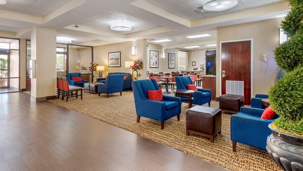 A spacious lobby with multiple seating areas, a reception desk, and a large potted plant. - Comfort Inn Columbus near Fort Benning (Columbus)