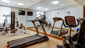 A gym with treadmills, elliptical machines, and weightlifting equipment.