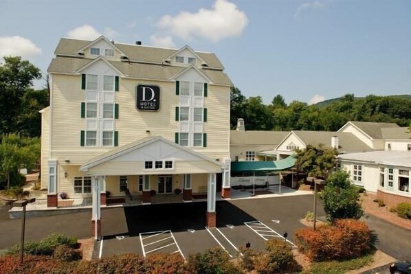 A two-story hotel with a covered entrance and a parking lot.