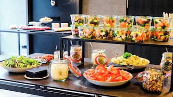 Ein reichhaltiges Buffet mit verschiedenen Speisen, darunter Salate, Früchte und Nüsse.