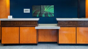 A reception desk with a dark blue wall and a modern abstract painting. - Fairfield Inn & Suites by Marriott McAllen Airport (McAllen)
