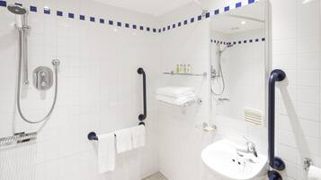 A modern bathroom with a walk-in shower, a sink, and a mirror.
