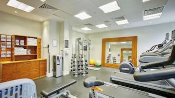 A gym with exercise equipment, a mirror, and a towel rack.