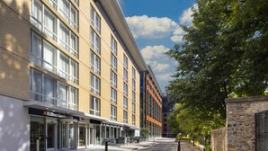 A hotel with a modern facade, large windows, and a clear sky. - Hilton Garden Inn Bristol City Centre (Bristol)
