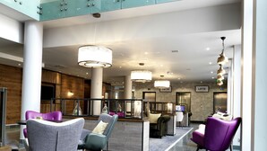 A modern lobby with seating areas, a reception desk, and elevators. - Hilton Garden Inn Birmingham Brindley Place (Birmingham)