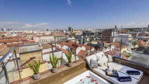 A rooftop terrace with a hot tub, seating area, and potted plants. - H10 Villa de la Reina Boutique Hotel (Madrid)