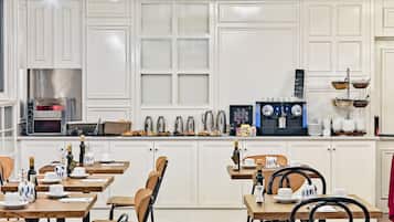 Una cocina moderna con armarios blancos, horno empotrado y espacio para café.