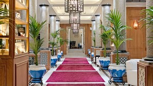 A grand hallway with a red carpet, ornate columns, and a large chandelier. - H10 Villa de la Reina Boutique Hotel (Madrid)