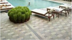 A swimming pool with lounge chairs and a small bush. - The HHI Kolkata (Kolkata)