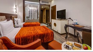 A hotel room with two beds, a desk, a TV, and a breakfast tray. - The HHI Kolkata (Kolkata)